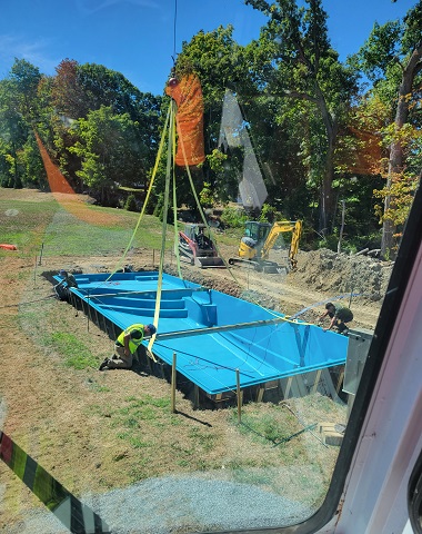 Crane setting a fiberglass pool